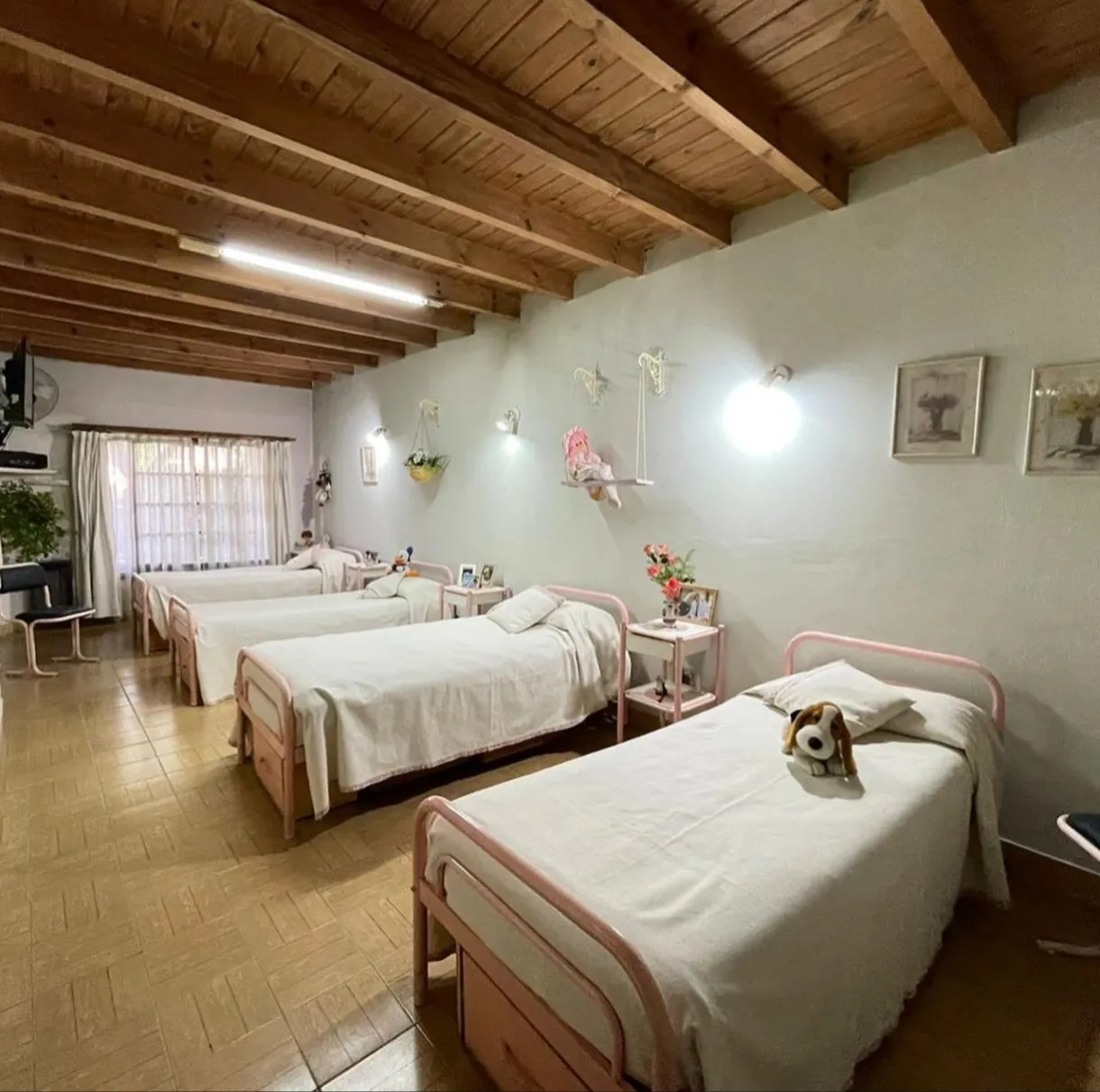 Dormitorio compartido con camas individuales y techo de madera