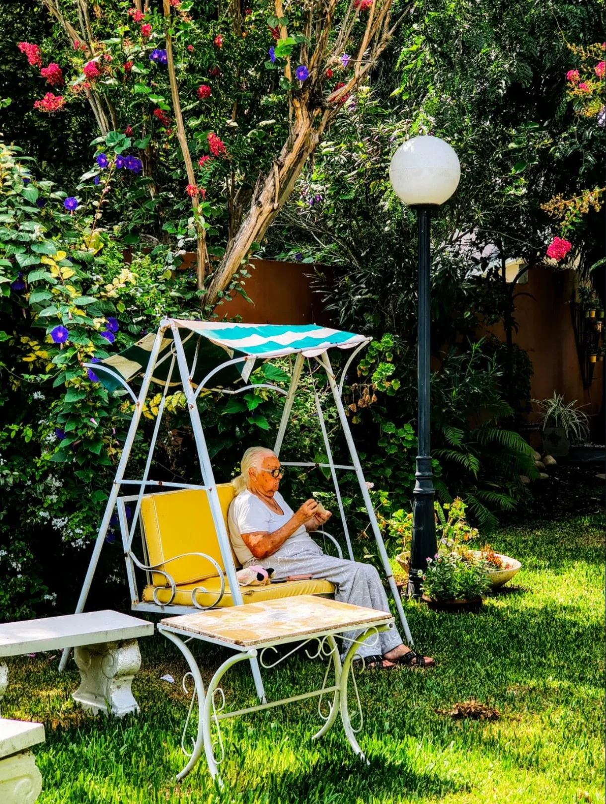Persona mayor sentada en una hamaca del jardín de Casa San Juan